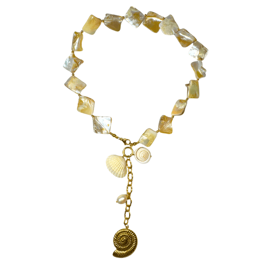 Necklace with yellow and white beads and shell charms on a white background