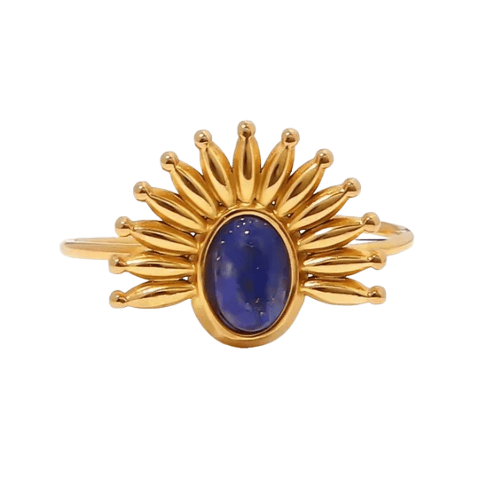 Gold ring with a blue gemstone on a white background