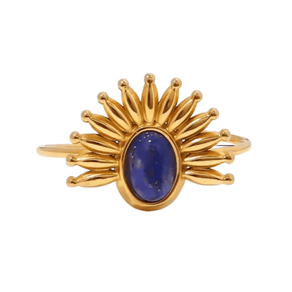 Gold ring with a blue gemstone on a white background