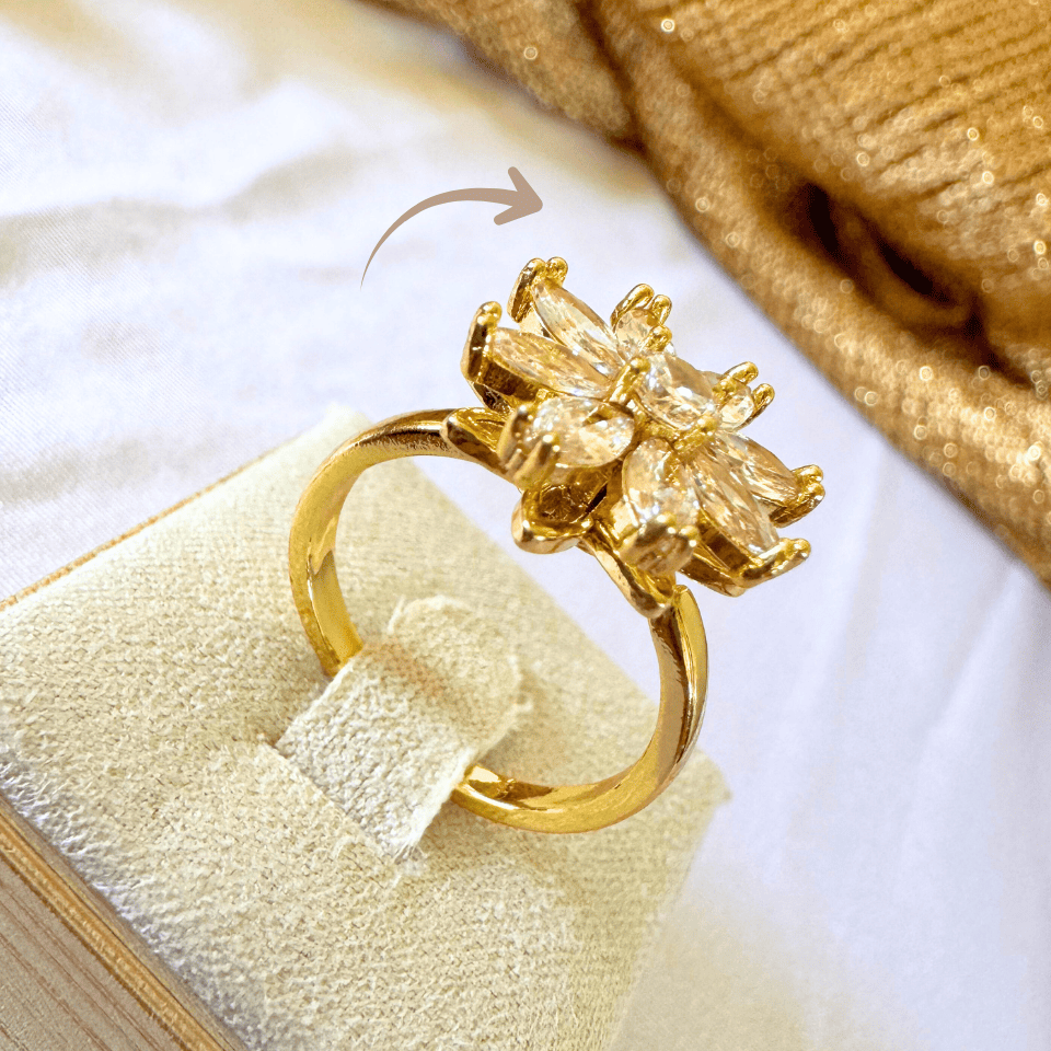 Gold ring with floral design on a white surface