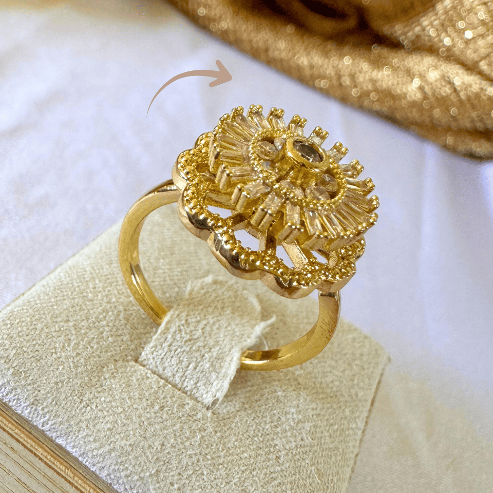 Gold ring with intricate design on a white background