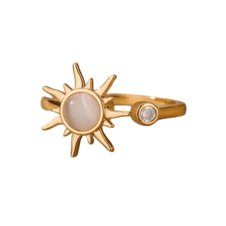 Gold sun-shaped ring with gemstones on a white background
