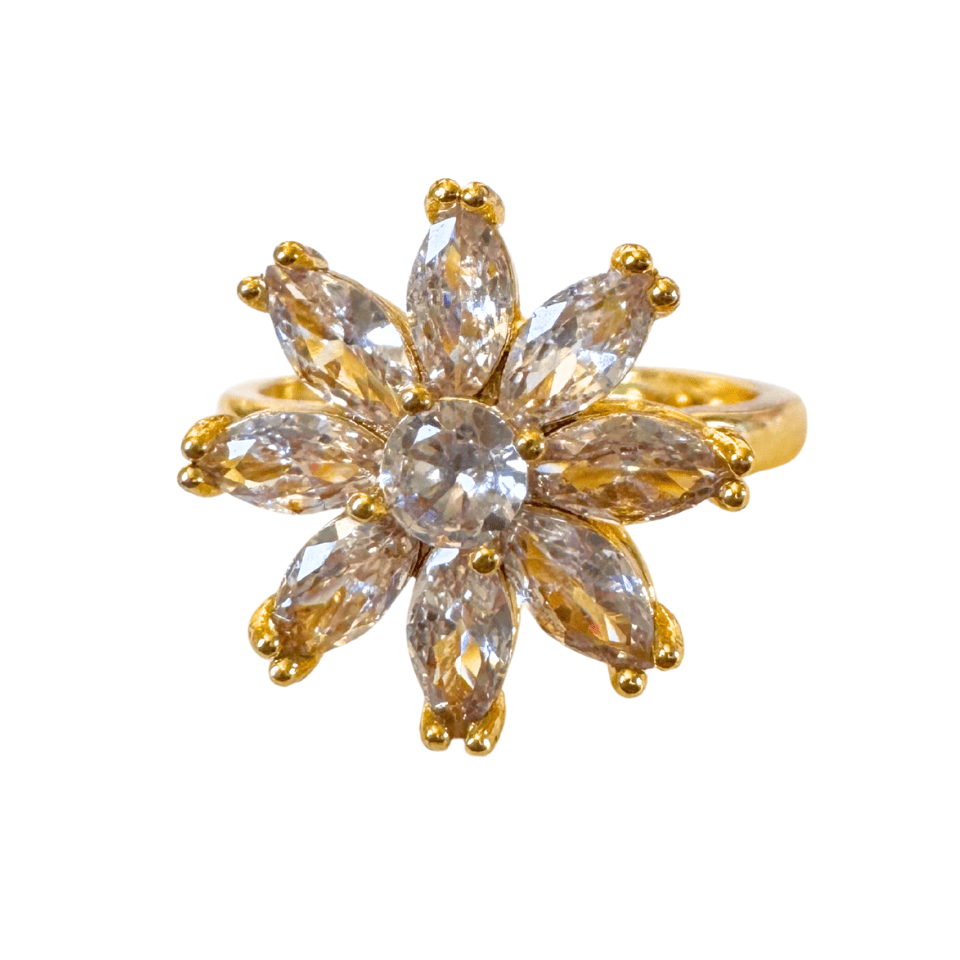 Gold ring with clear gemstones on a white background