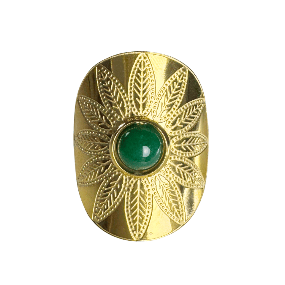 Gold decorative object with a green gemstone on a white background