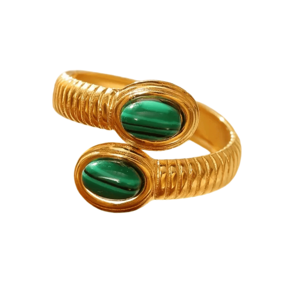 Gold bracelet with green stones on a white background