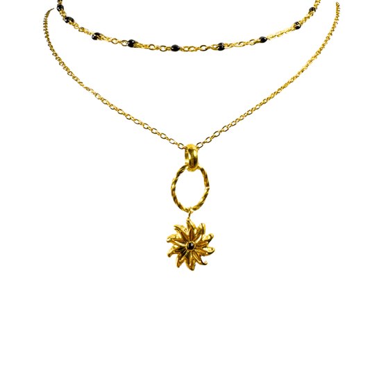Gold necklace with a sunflower pendant on a white background