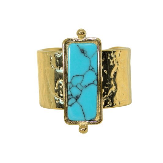 Gold cuff bracelet with a turquoise stone on a white background
