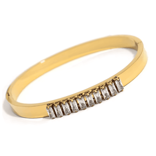 Gold bracelet with baguette cut diamonds on a white background