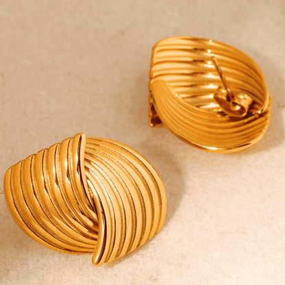 Pair of gold earrings on a beige background