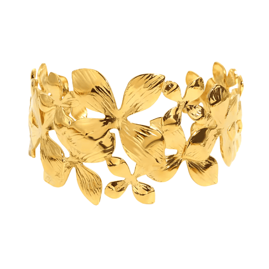 Gold bracelet with leaf-like designs on a white background