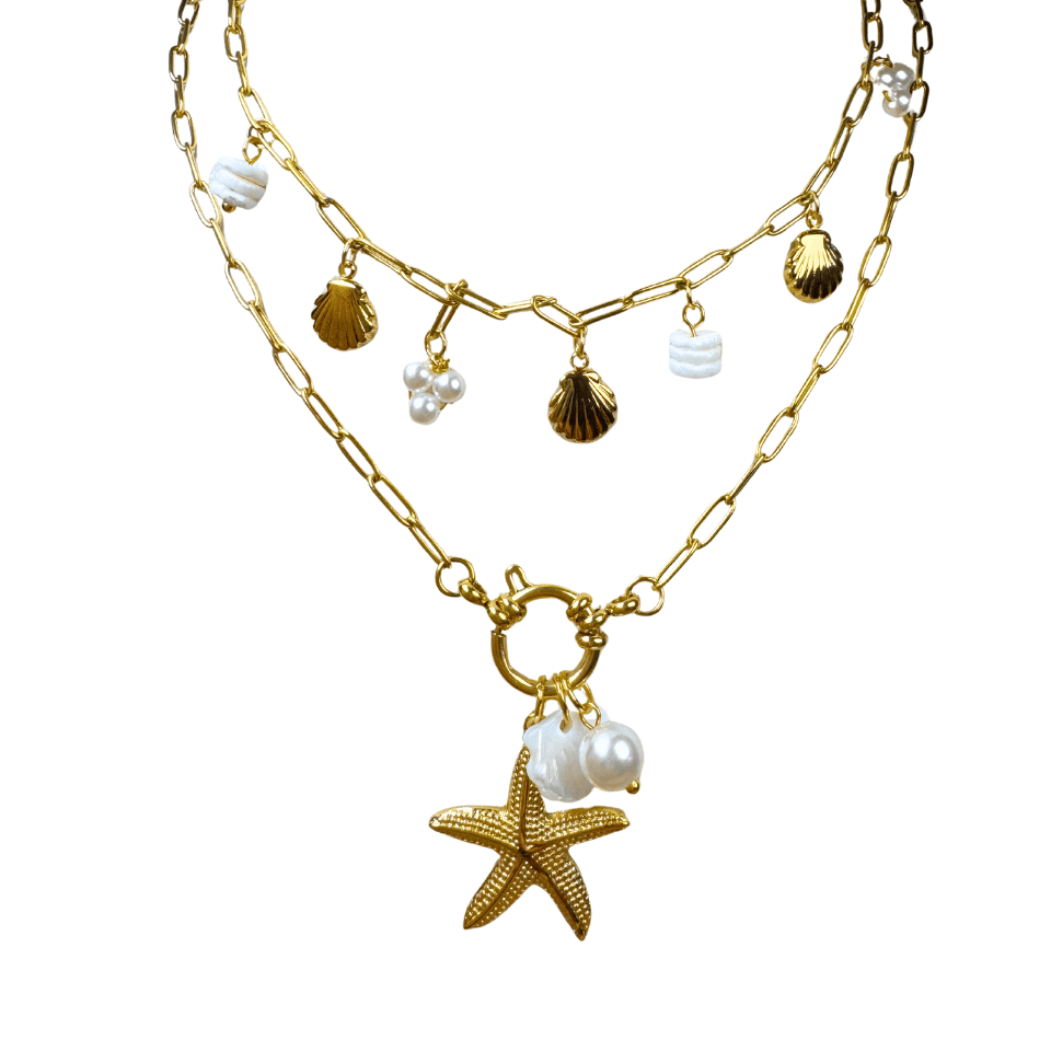 Gold necklace with starfish and shell charms on a white background