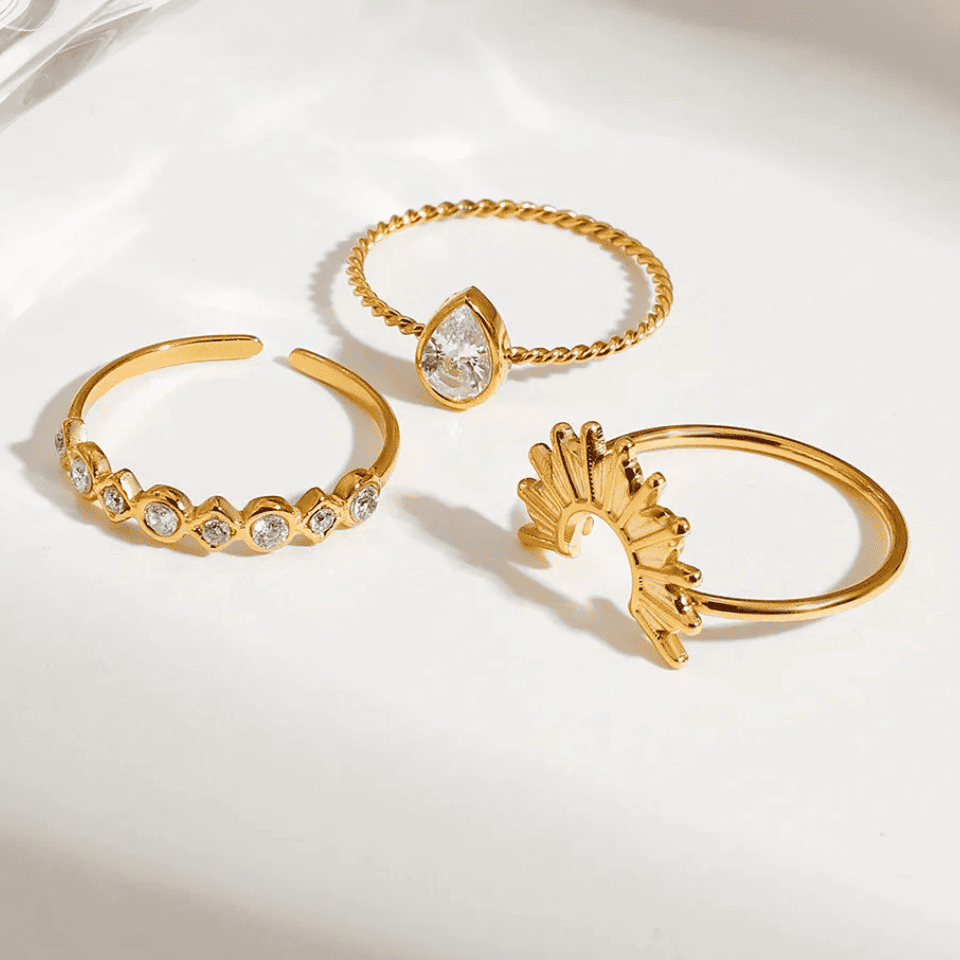 Three gold rings with different designs on a light background