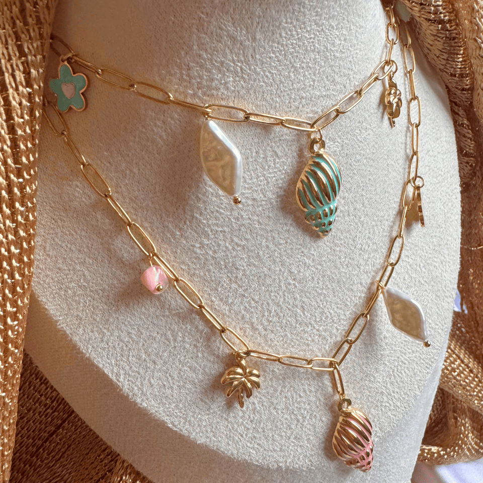 Gold chain necklace with charms on a mannequin bust.