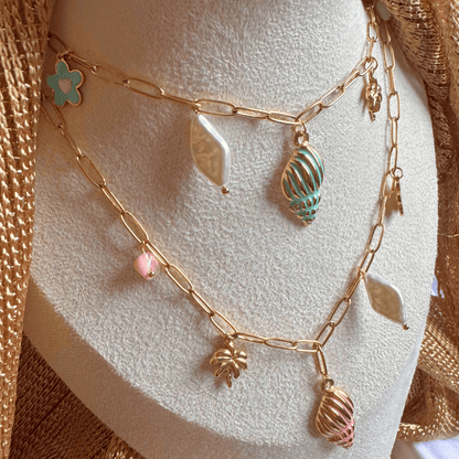 Gold chain necklace with charms on a mannequin bust.