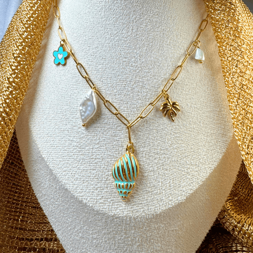 Gold necklace with shell charm on a white stand