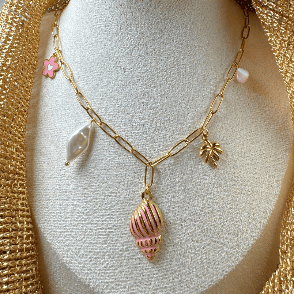 Gold necklace with shell and flower charms on a mannequin bust.